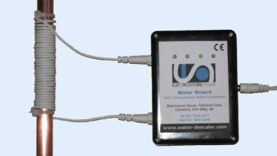 An electronic water descaler with the coils of wire wrapped around a water pipe